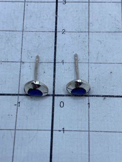 Aretes sobre fondo claro mostrando el engaste manual del lapislázuli