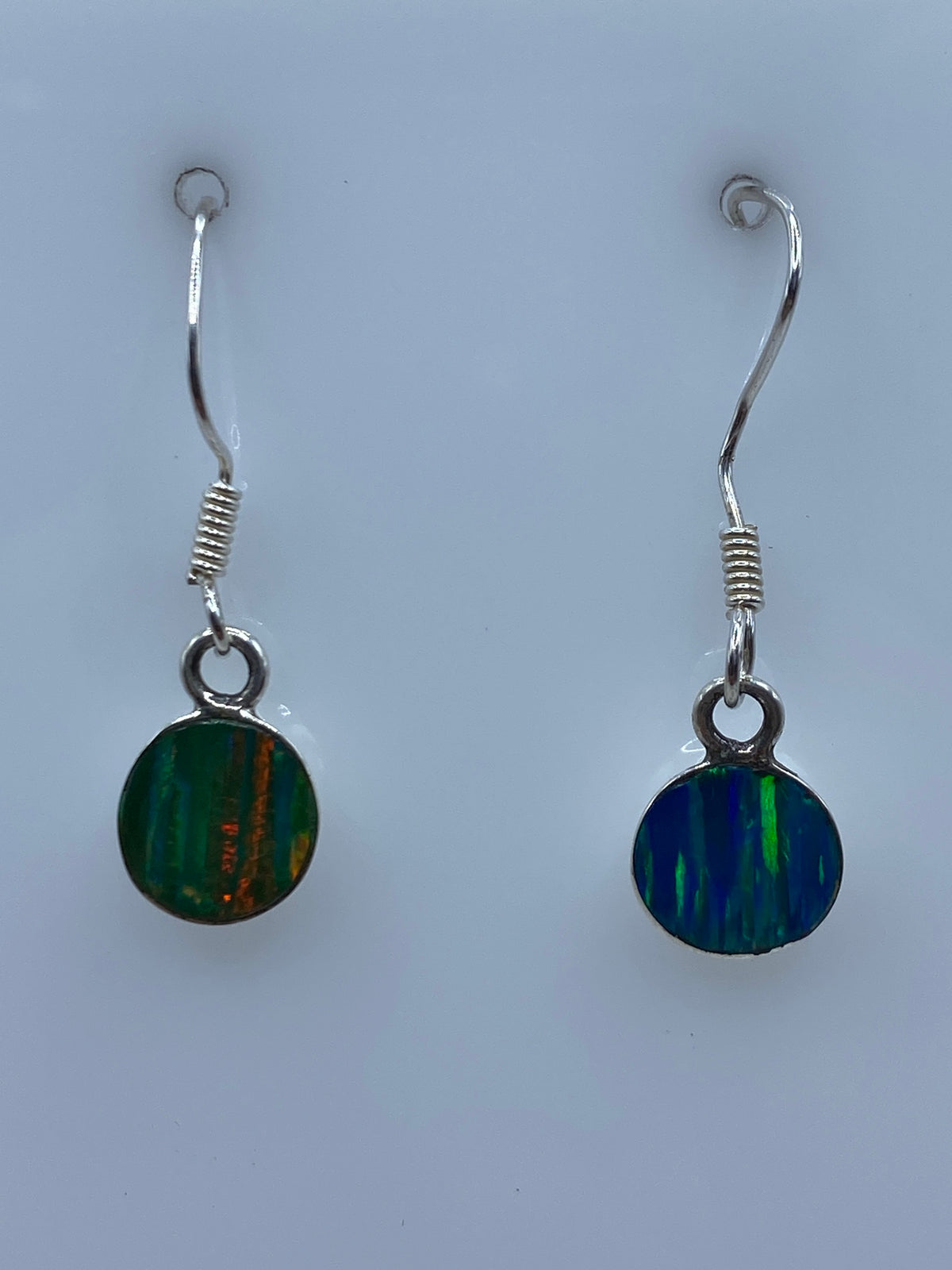 Par de aretes de plata con ópalo de fuego que destella en verde y azul