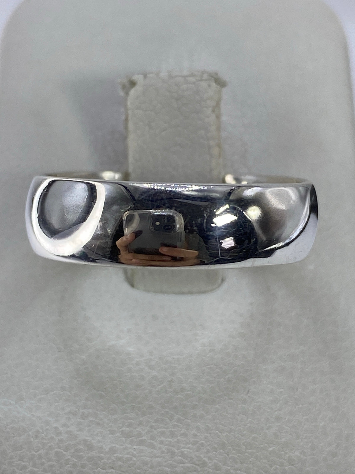Anillo de plata 925 minimalista pulido en la mano, vista frontal