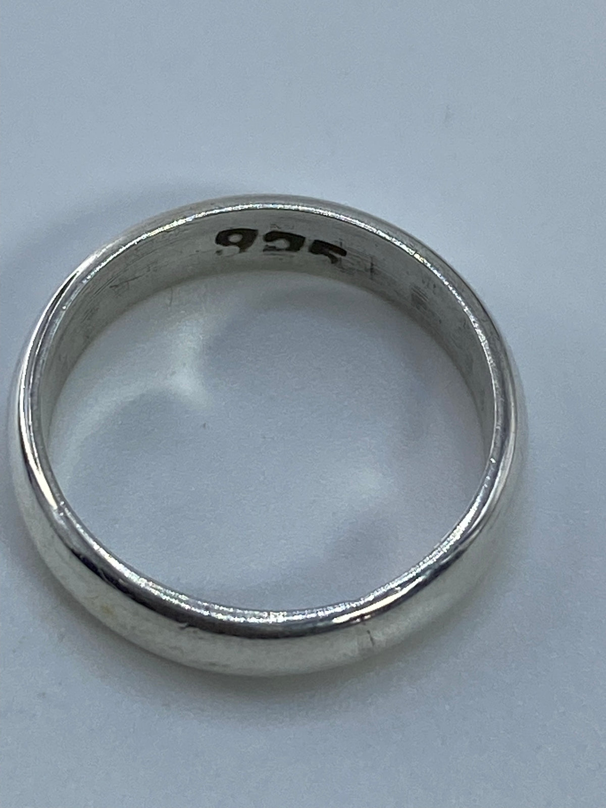 Anillo de plata pura minimalista en vista de perfil mostrando el pulido brillante