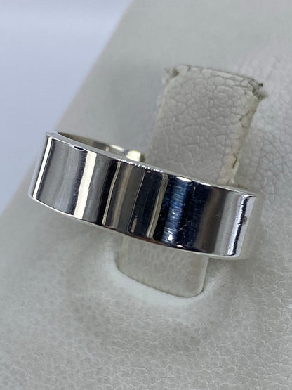 Detalle del anillo plata en la mano, mostrando el espejo brillante