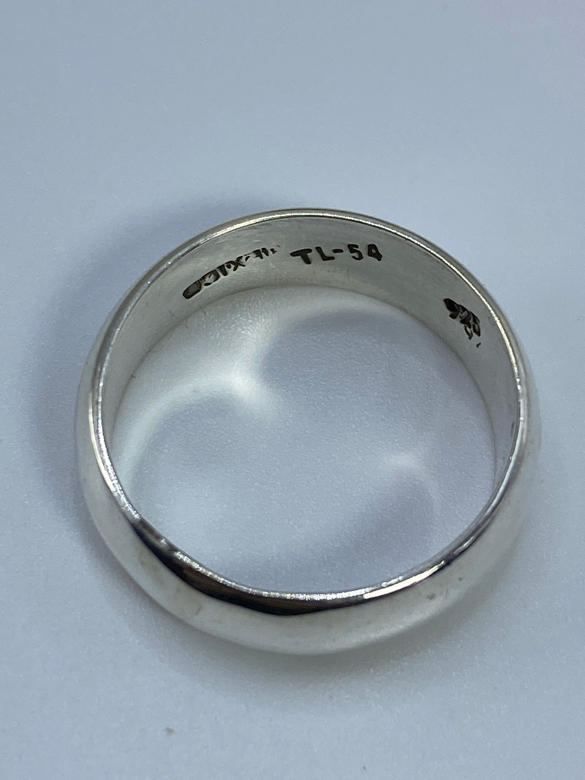 Anillo de plata en la mano, demostrando el confort y el brillo de la banda pulida