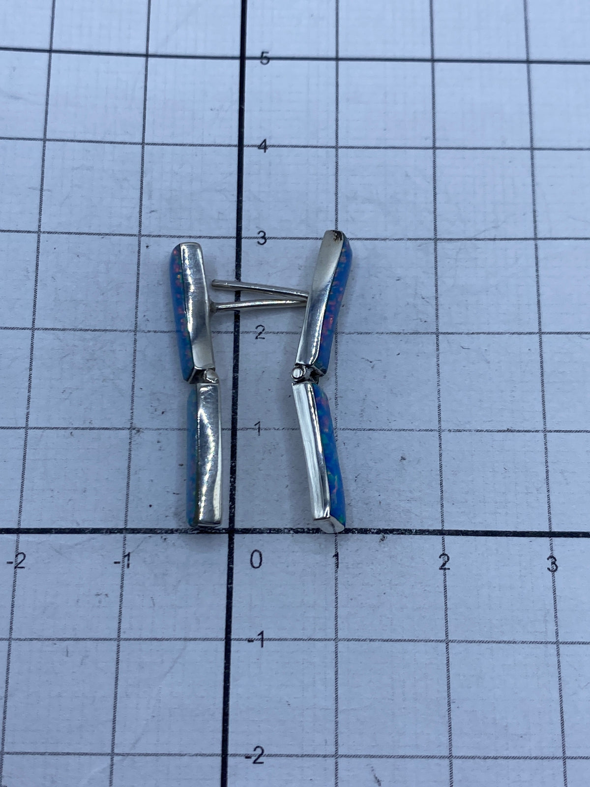 Aretes sobre escala mostrando el largo de 3 cm por pieza