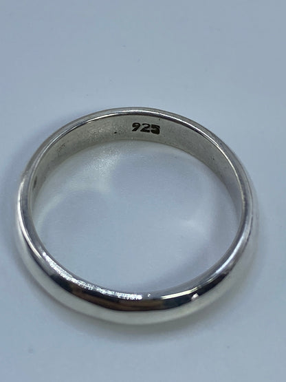 Anillo de banda lisa de plata 925 sobre fondo blanco, vista de perfil
