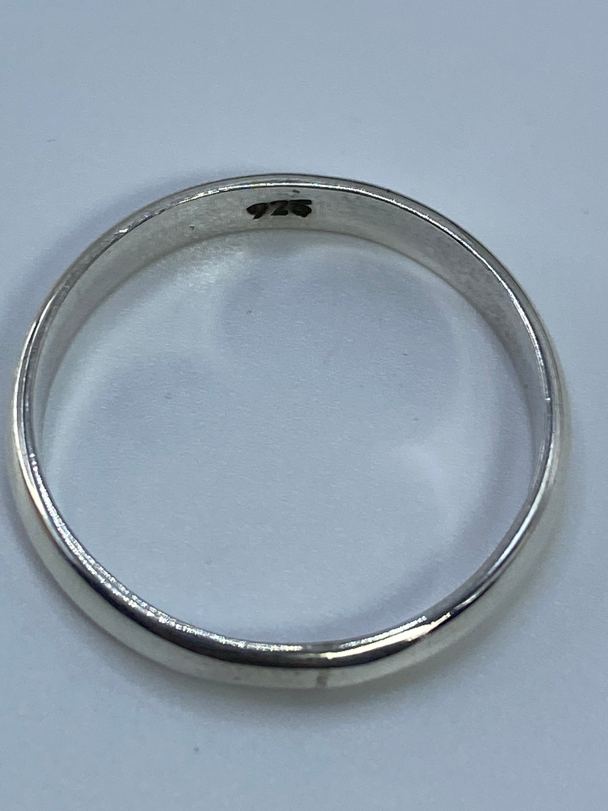 Anillo en dedo con luz natural reflejándose en la plata pura