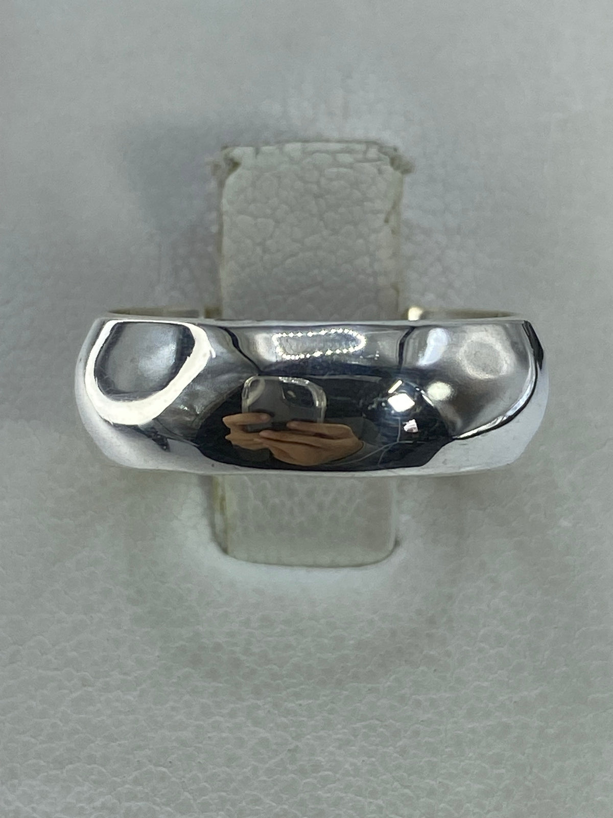 Anillo de plata 925 pulido a espejo, banda minimalista en la mano de una mujer