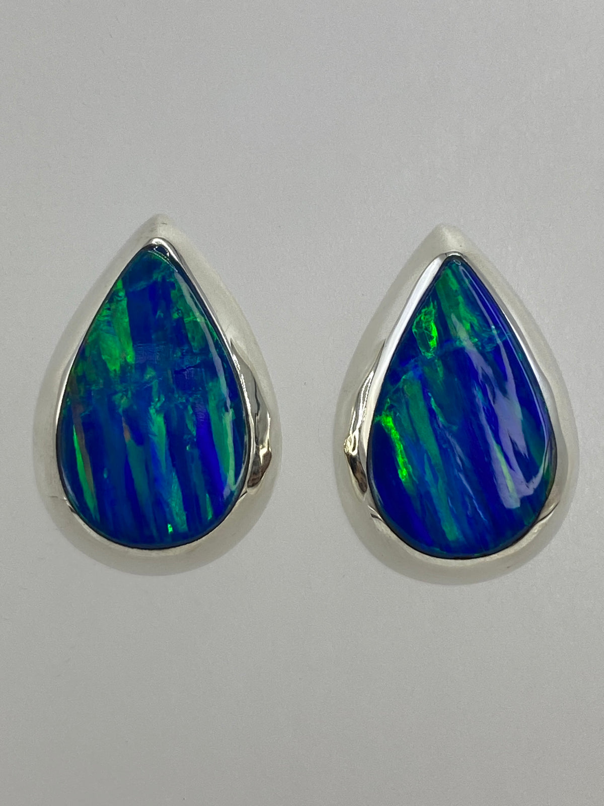 Dos aretes sobre escala milimétrica verificando medidas de 2 × 1 cm