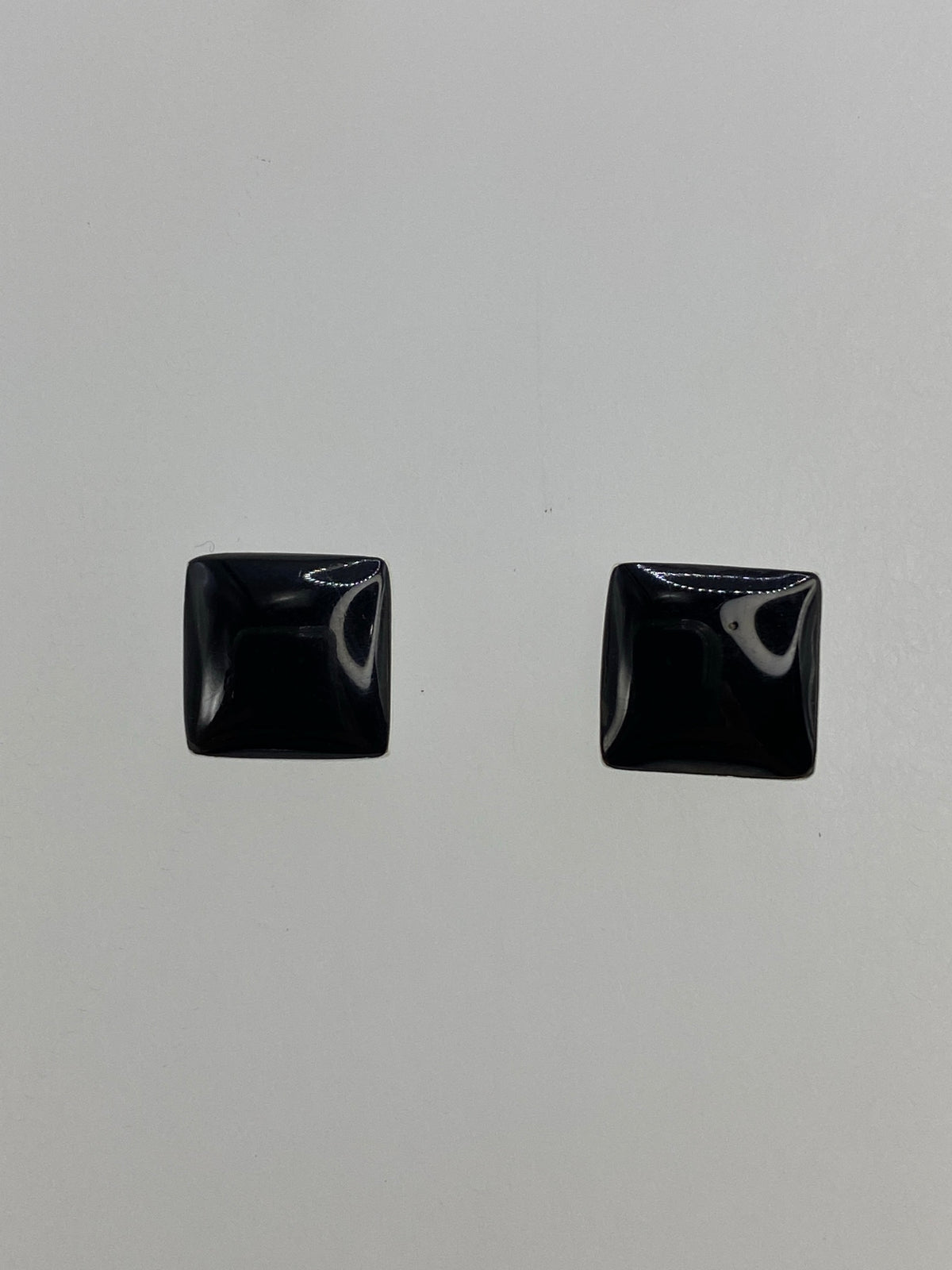 Par de aretes de plata 950 con ónix negro engastado, vista frontal mostrando el diseño minimalista