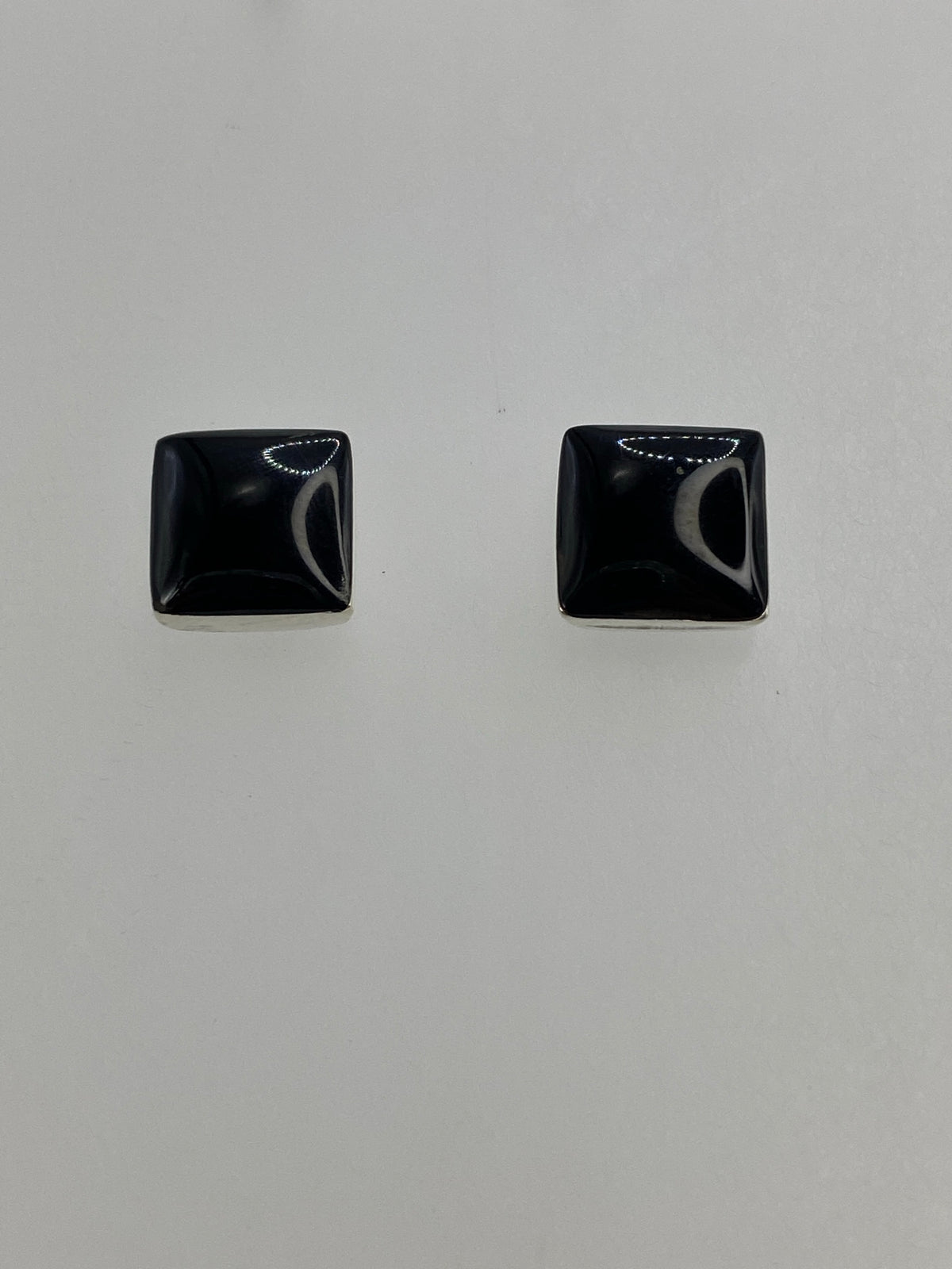 Detalle lateral del arete de plata con ónix negro pulido y postes de plata