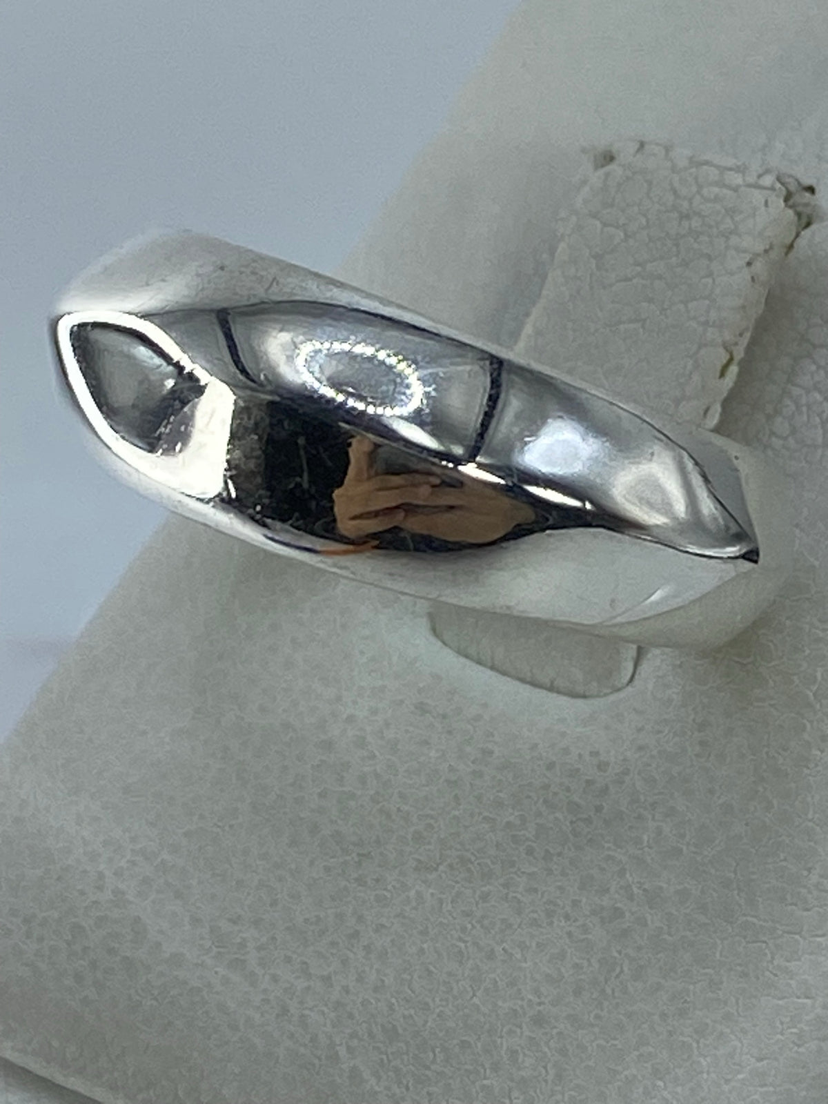 Anillo de plata con acabado espejo mostrando reflejo de luz