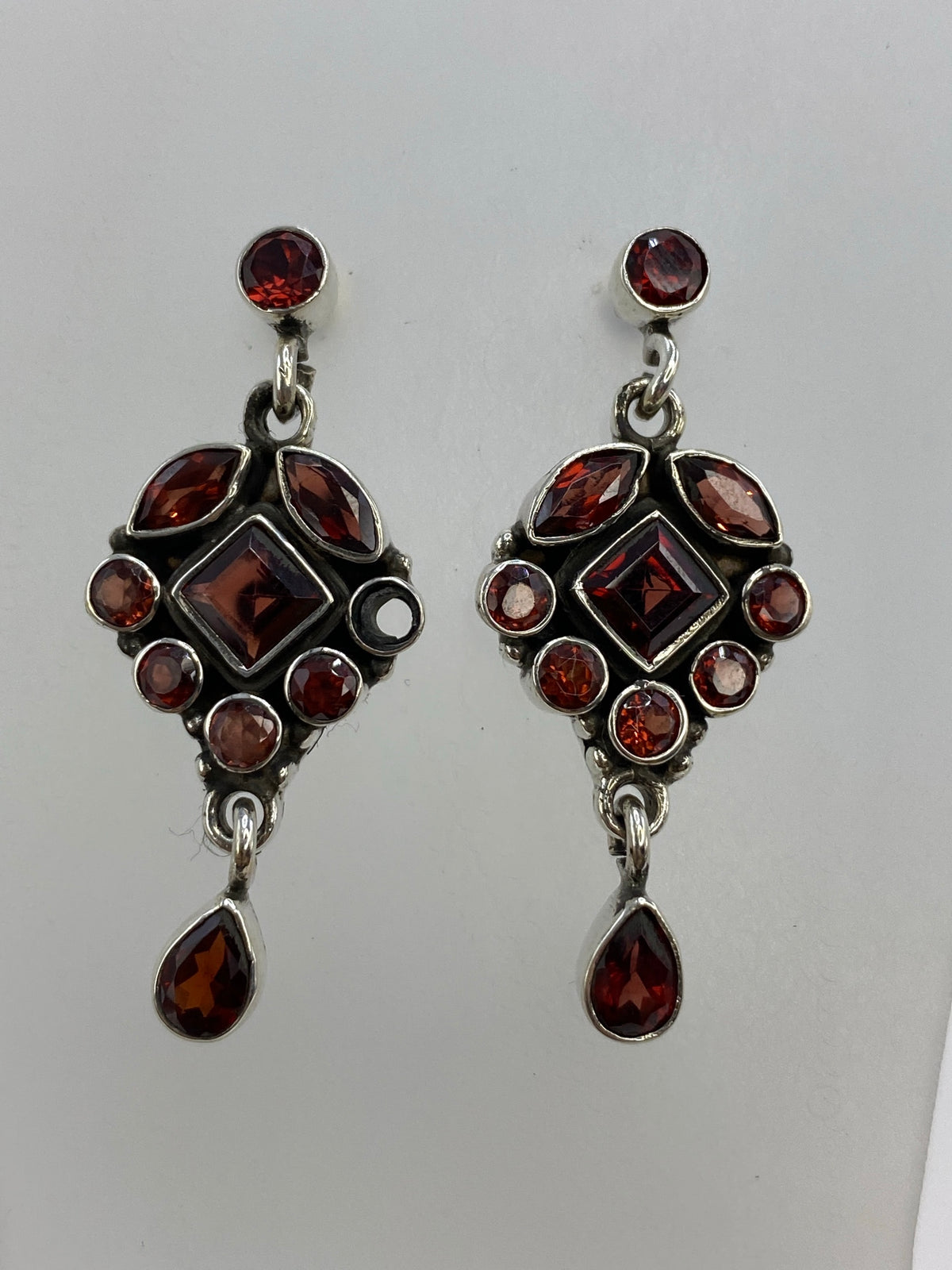Par de aretes de plata con circonia morada en diseño art-déco, vista frontal