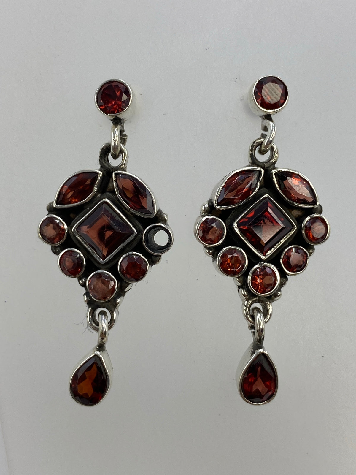 Aretes sobre papel milimetrado midiendo 3.8 cm de largo