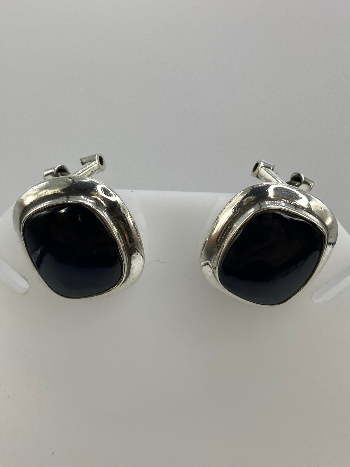 Aretes sobre regla milimetrada mostrando tamaño de 2 × 1.7 cm