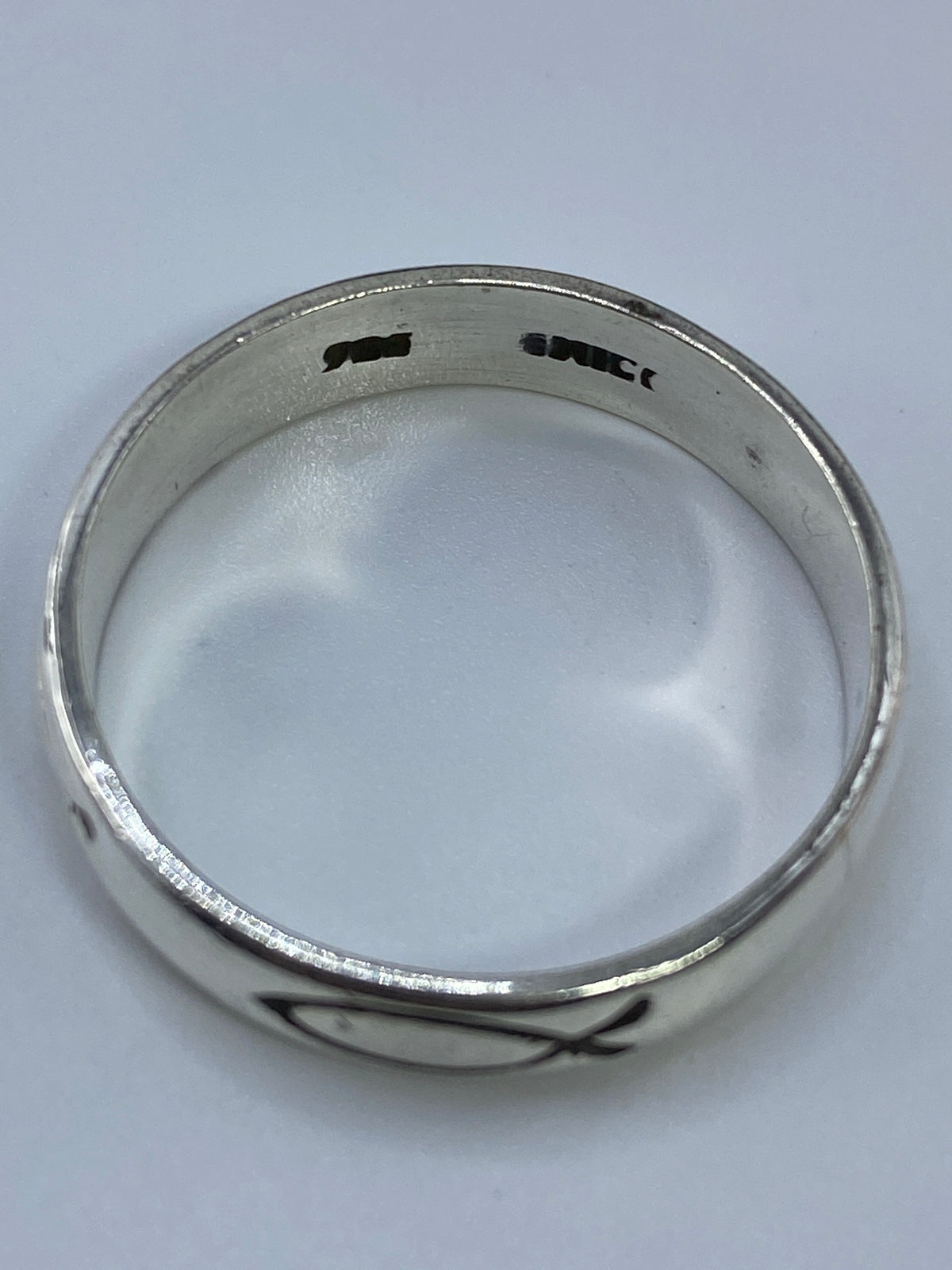 Anillo de plata sobre fondo blanco mostrando el Quinto de autenticidad