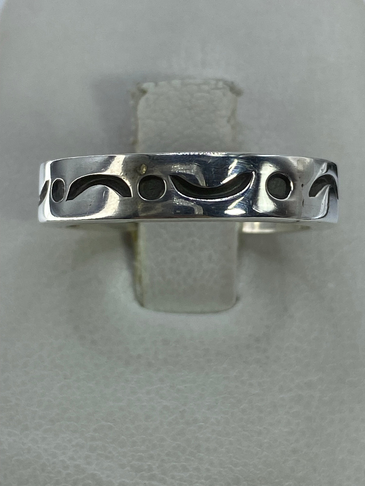 Anillo de plata calado con patrón geométrico simétrico en la mano