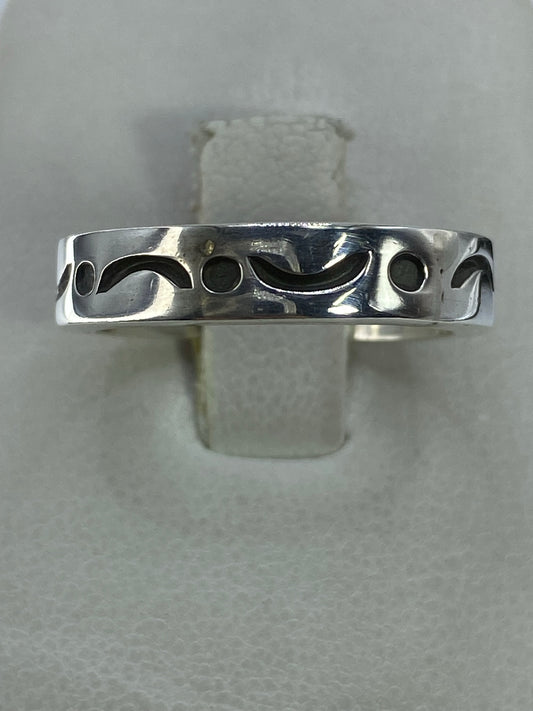 Anillo de plata calado con patrón geométrico simétrico en la mano