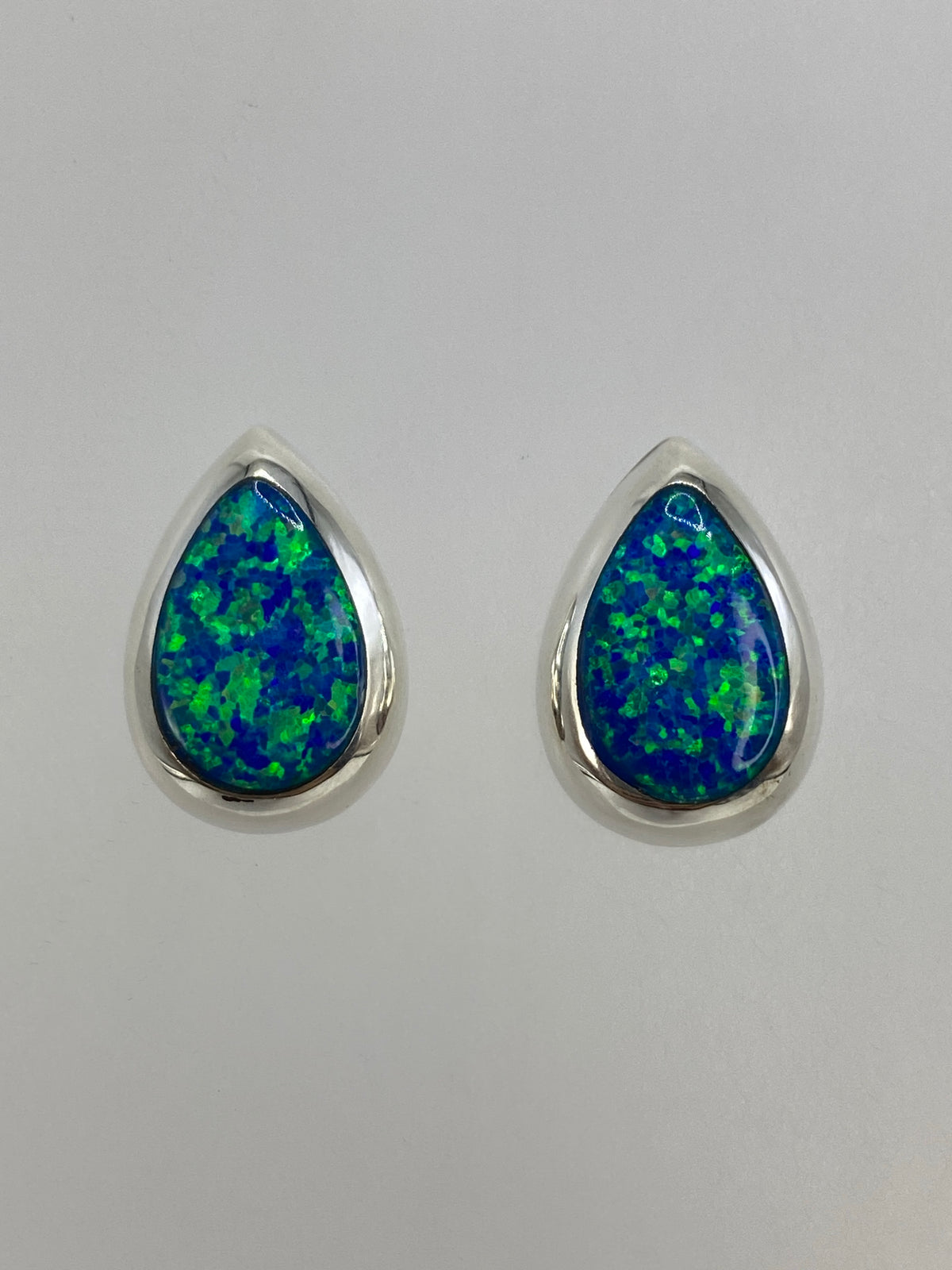 Par de aretes de plata con ópalo de fuego azul engastado, vista frontal