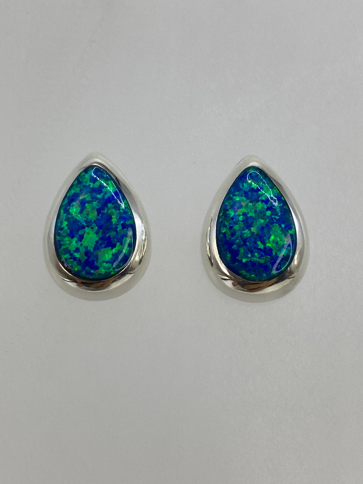 Detalle de un arete mostrando el ópalo azul en engaste de plata 925