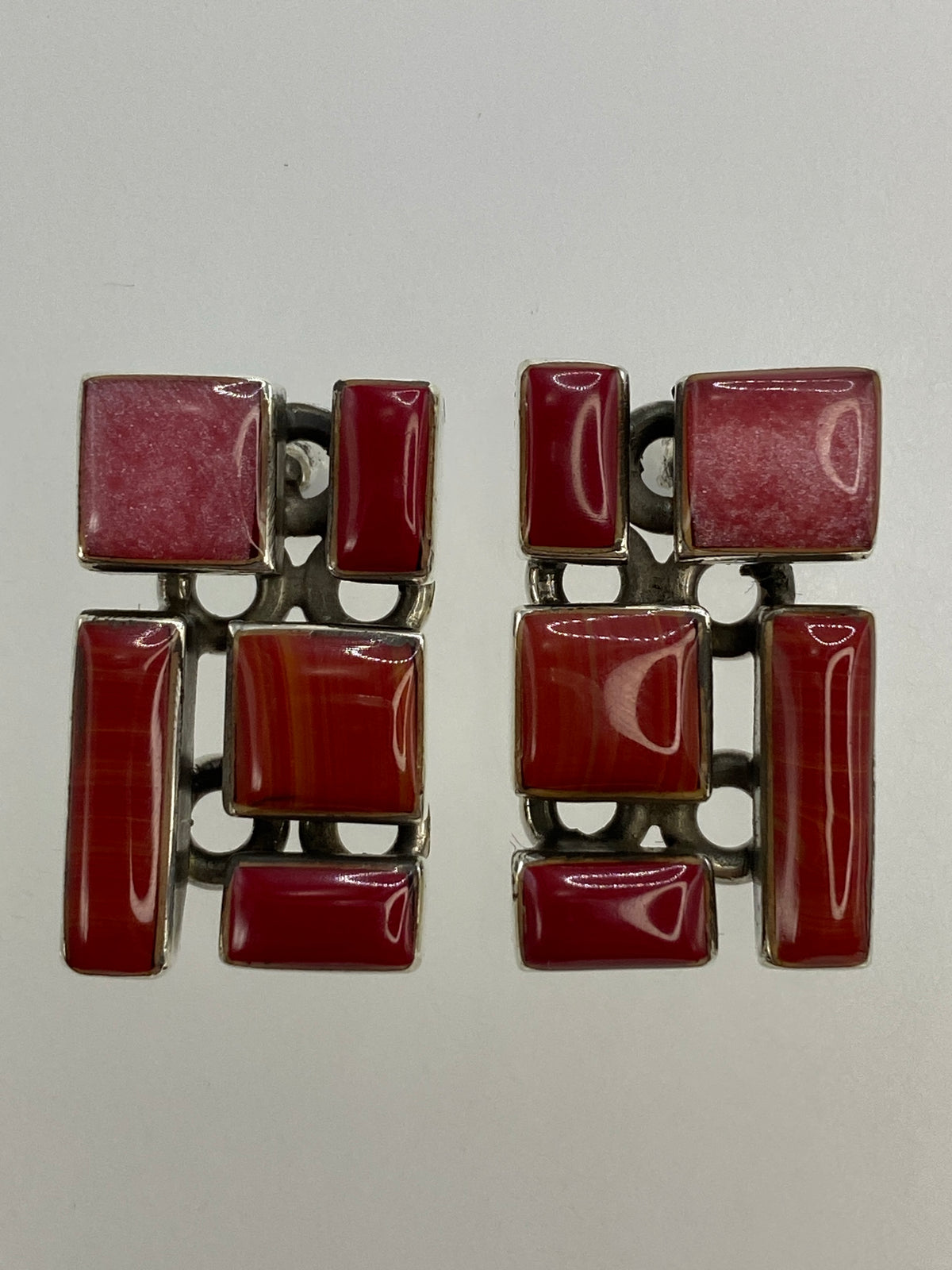 Aretes sobre regla milimétrica mostrando largo de 2.5 cm y ancho de 1.4 cm