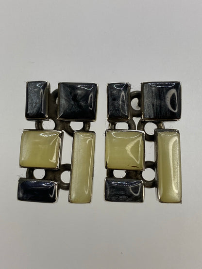 Aretes de plata con coral blanco e incrustación de lapislázuli negro, vistos de frente