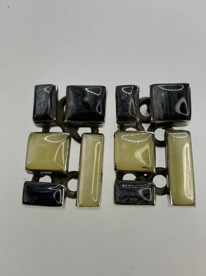 Detalle de uno de los aretes mostrando el engaste de coral y lapislázuli