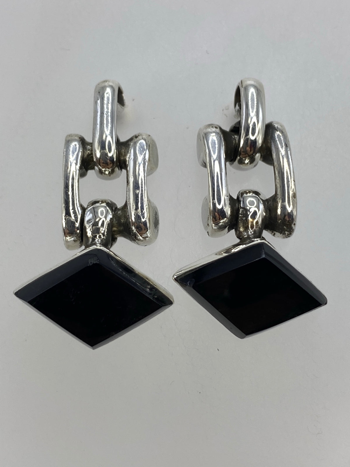 Detalle de los aretes mostrando el engaste de ónix negro y el brillo de la plata 925