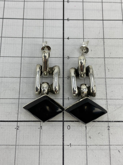 Escala comparativa de los aretes de 3.4 cm sobre cuadrícula milimetrada