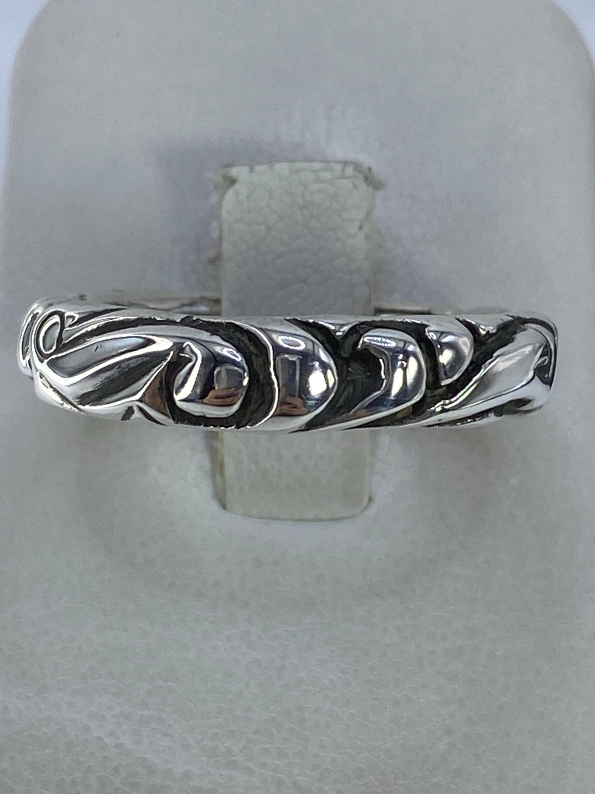 Anillo de plata geométrico étnico en la mano sobre fondo natural
