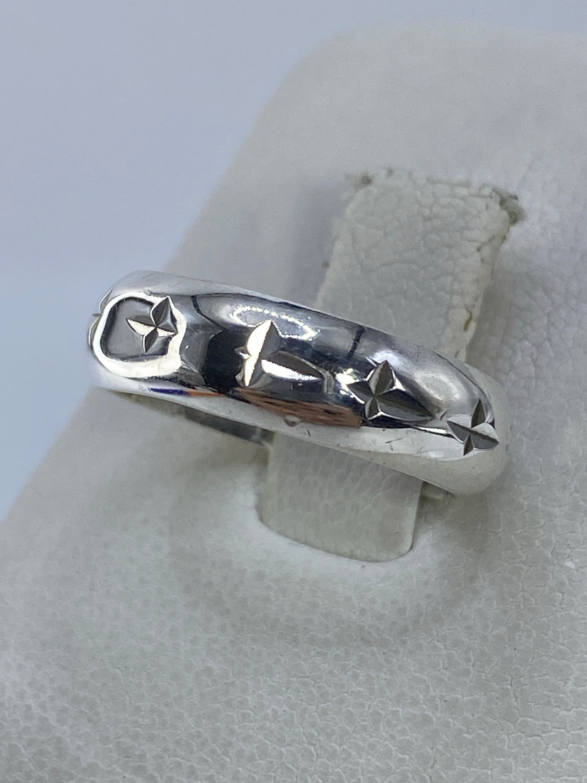 Anillo de plata minimalista puesto en dedo, mostrando detalles de las estrellas