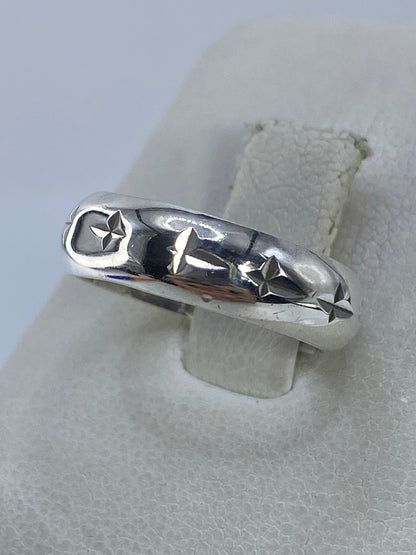 Anillo de plata minimalista puesto en dedo, mostrando detalles de las estrellas