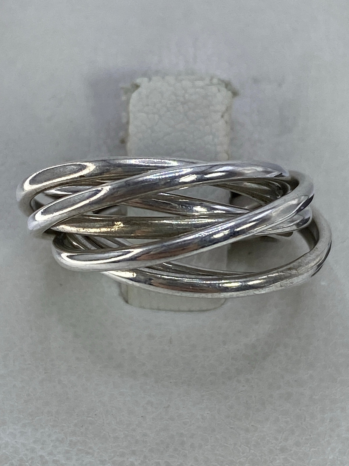 Anillo de plata con bandas enlazadas minimalista visto desde arriba