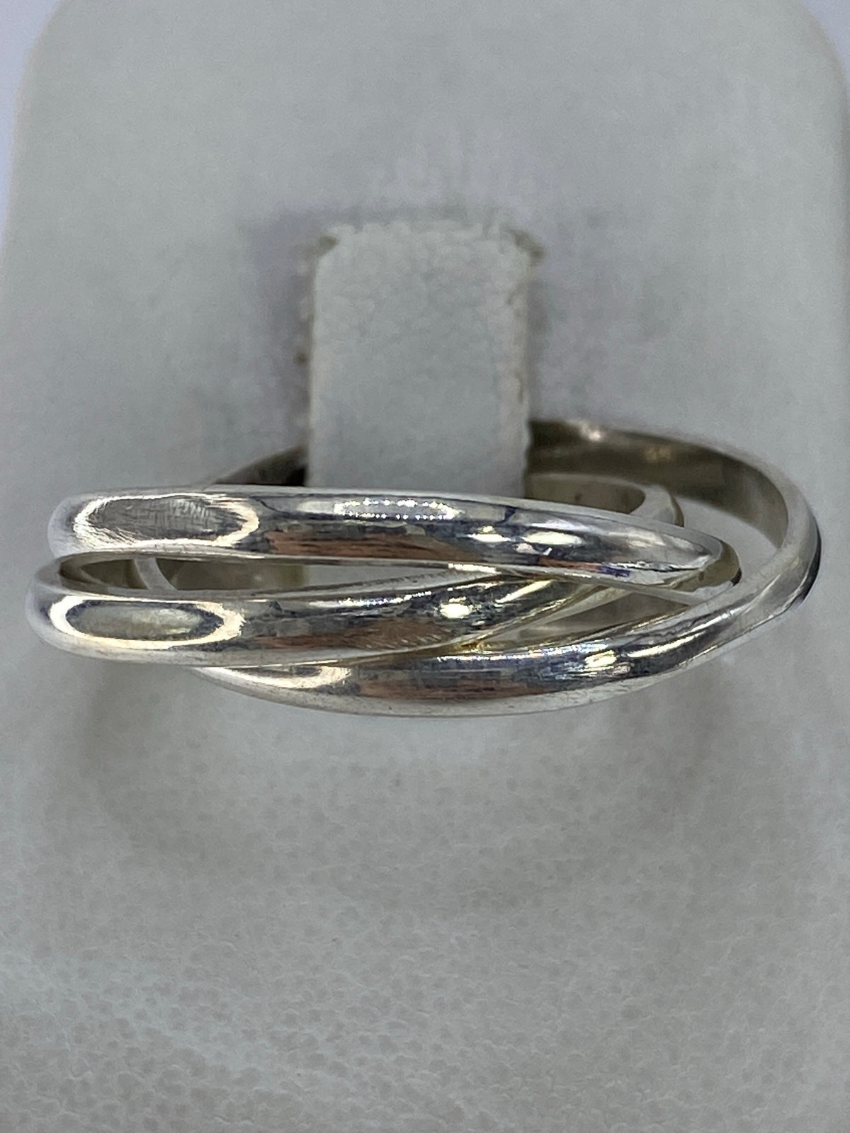 Anillo de tres bandas de plata 925 en la mano, diseño minimalista pulido