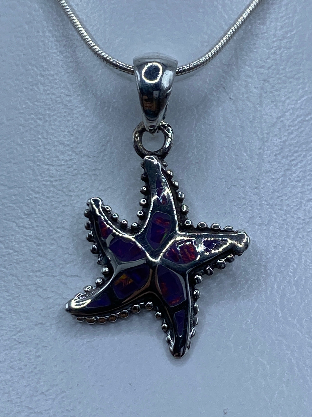Dije de estrella de mar en plata 950 con ópalo de fuego morada sobre cadena de plata
