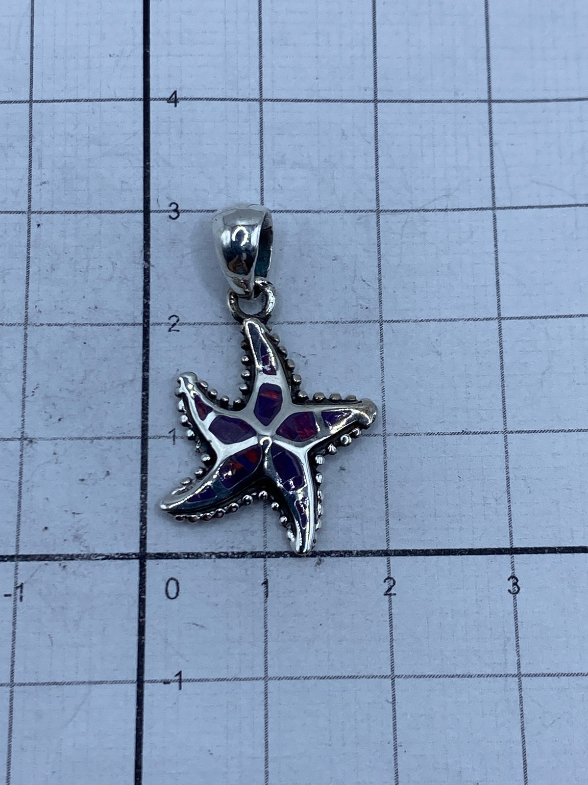 Dije de estrella de mar con ópalo morada en escala de centímetros