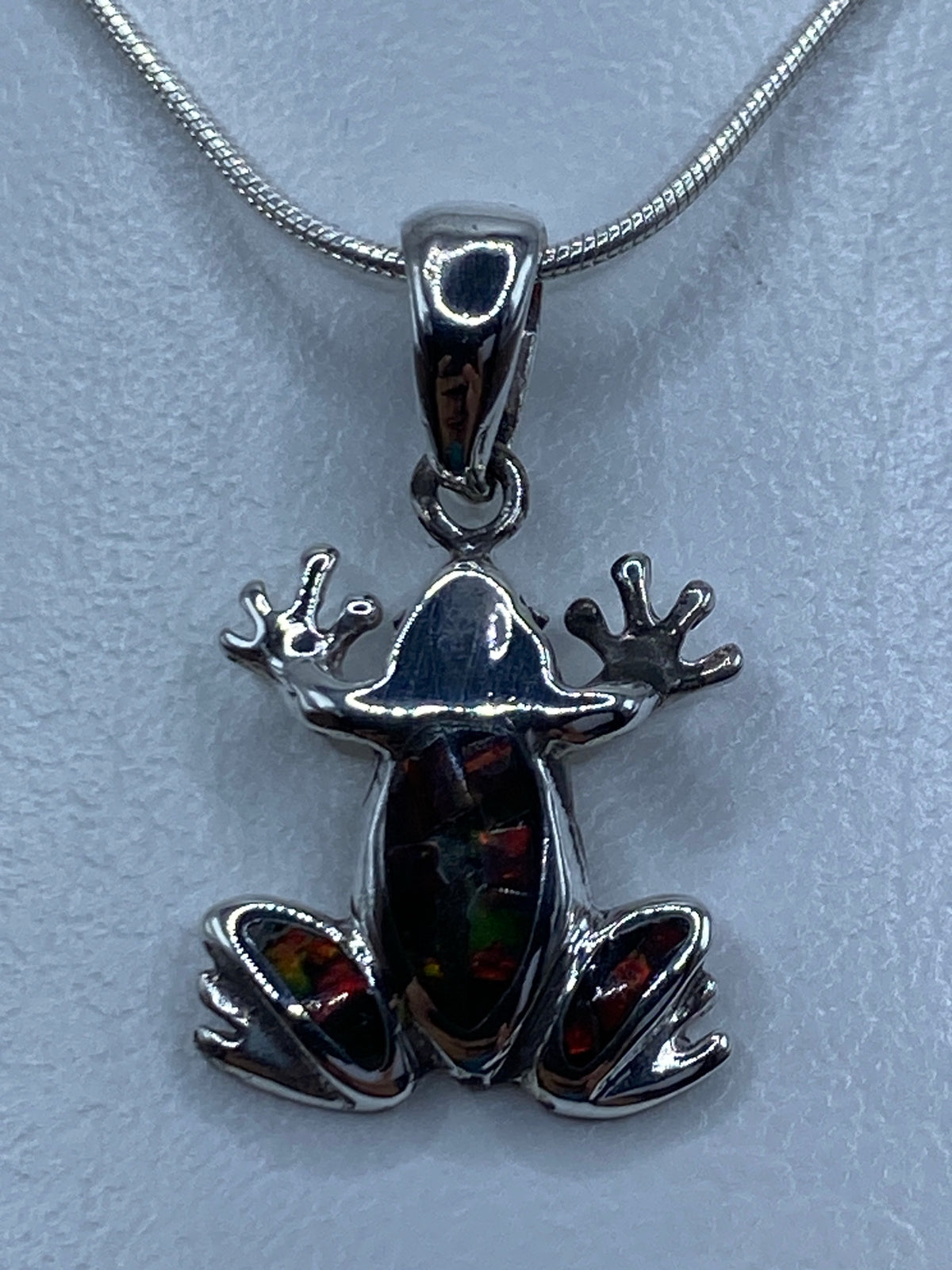 Dije rana de plata 950 con ópalo de fuego multicolor, visto de frente en cadena