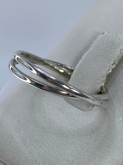 Anillo minimalista de dos bandas en mano, mostrando el pulido espejo