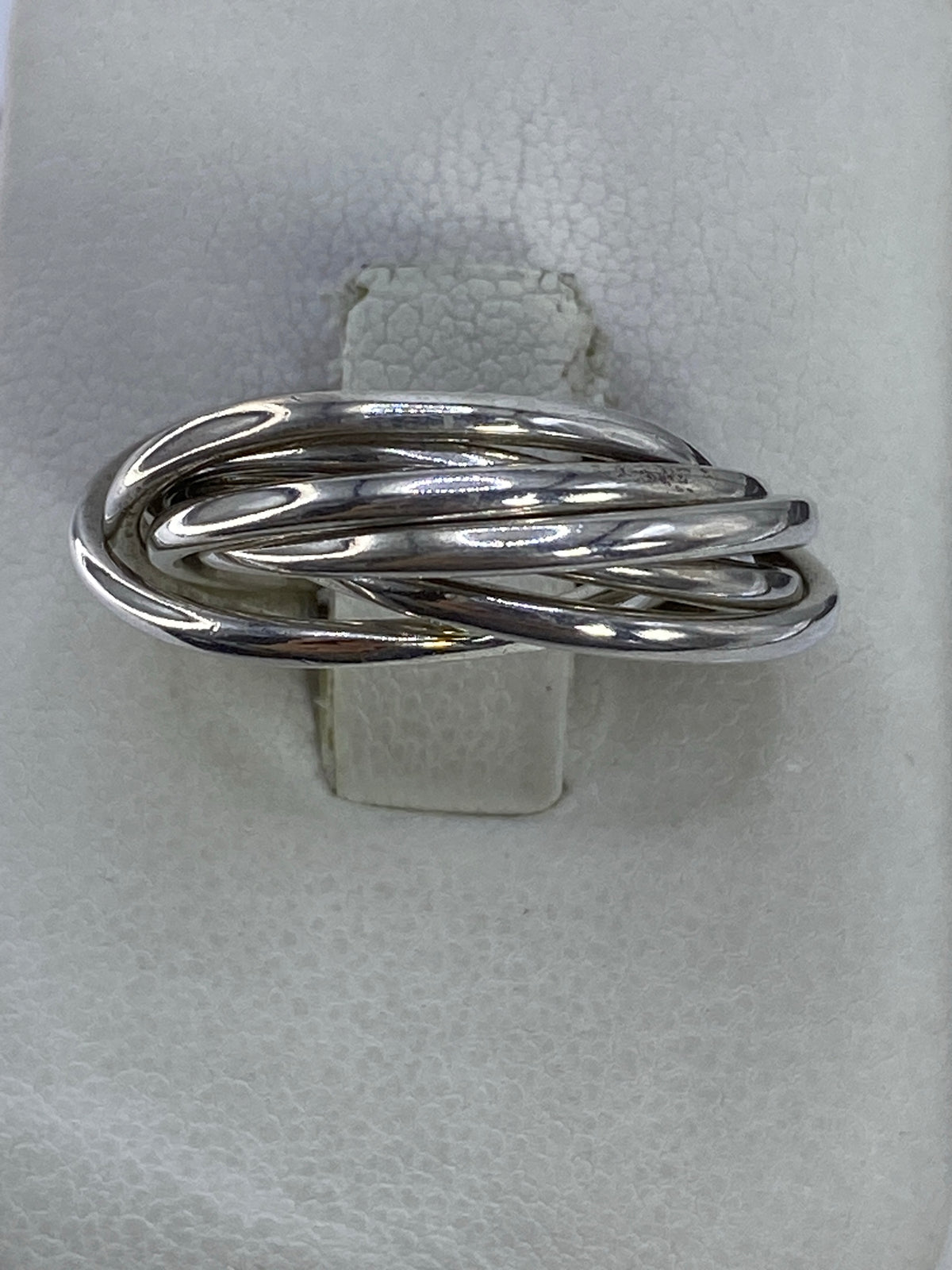 Anillo de plata 925 con bandas entrelazadas visto desde arriba sobre fondo blanco