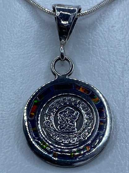 Dije de plata con ópalo de fuego multicolor en diseño del Calendario Maya, colgante sobre cadena plateada