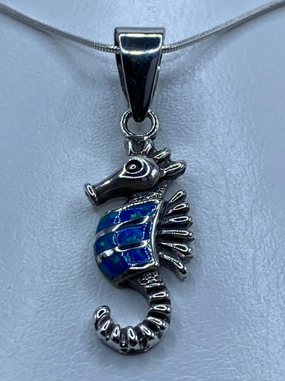 Detalle del ópalo de fuego azul en la cola del caballito de mar grabado a mano
