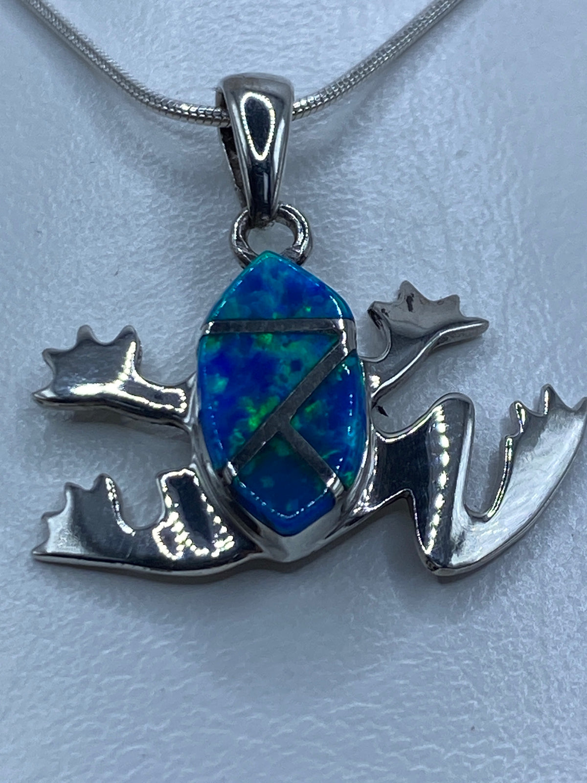 Dije de rana en plata 925 con ópalo de fuego azul colgando de cadena de serpentina