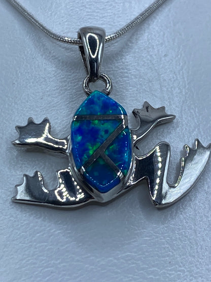Dije de rana en plata 925 con ópalo de fuego azul colgando de cadena de serpentina