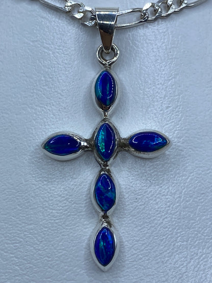 Dije cruz de plata 950 con ópalo de fuego azul engastado, colgante de frente