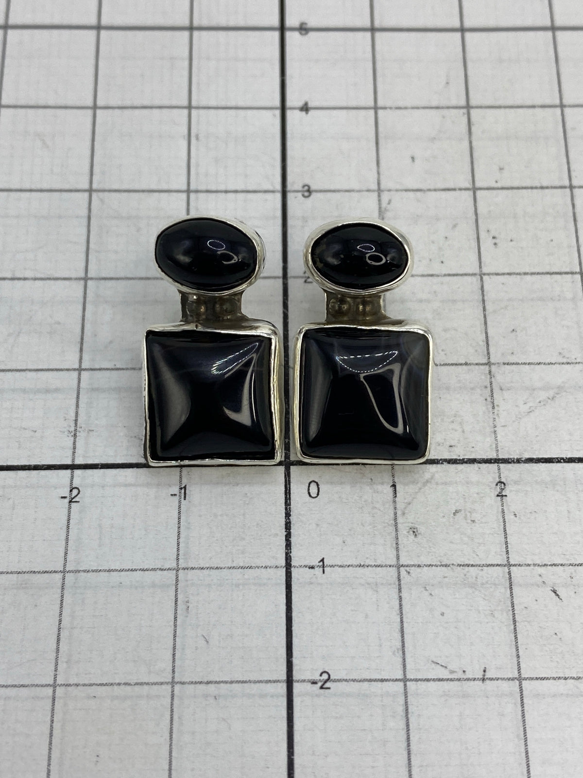 Aretes pesados en balanza de joyería, 7.06 gramos el par