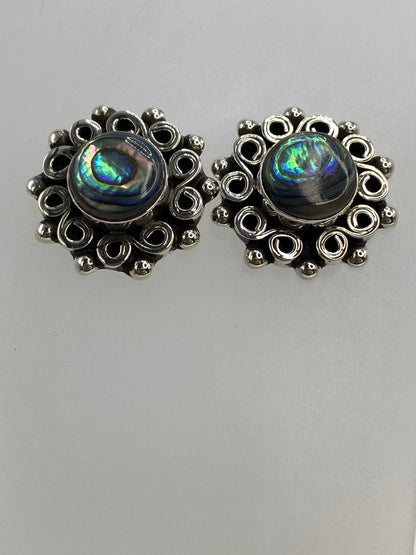 Aretes de abulón al lado derecho en detalle, mostrando el engaste ornamental en plata