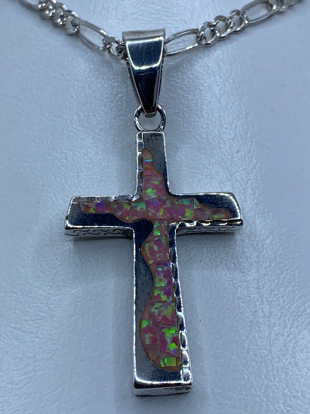 Dije cruz de plata 950 con ópalo de fuego rosa en tonos cálidos y reflejos dorados