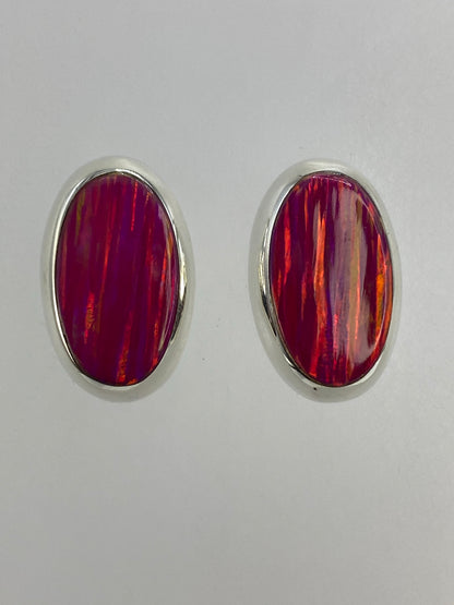 Par de aretes de plata con ópalo de fuego rosa, vista frontal mostrando los reflejos cálidos