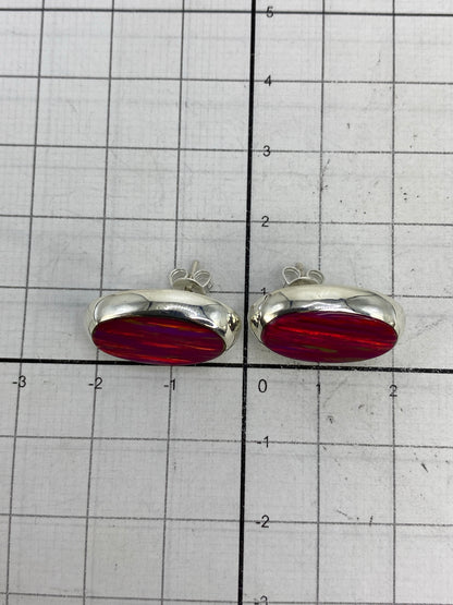 Aretes sobre fondo blanco destacando el brillo y color rosa del ópalo