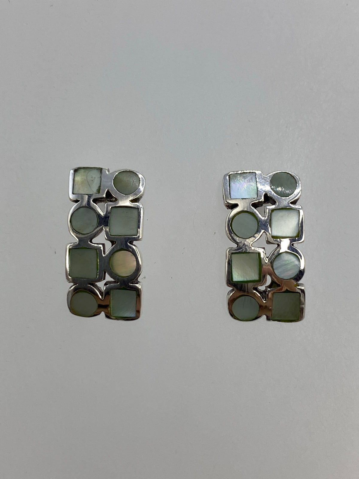 Par de aretes de plata con concha de abulón blanca, colgando ligeramente