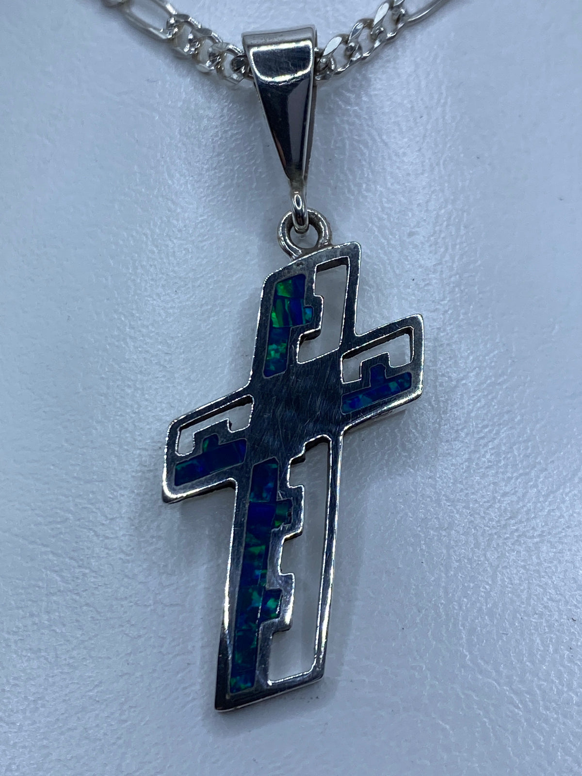 Cruz de plata 950 con ópalo de fuego azul, colgando de una cadena, vista frontal