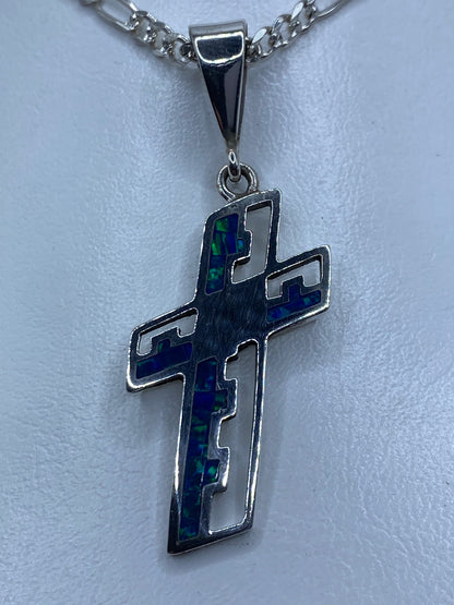 Cruz de plata 950 con ópalo de fuego azul, colgando de una cadena, vista frontal